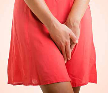 Close up of a woman with hands holding her crotch isolated in a pink background